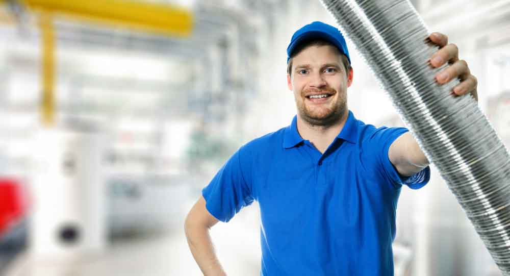 An HVAC technician holding an aluminum duct tube.